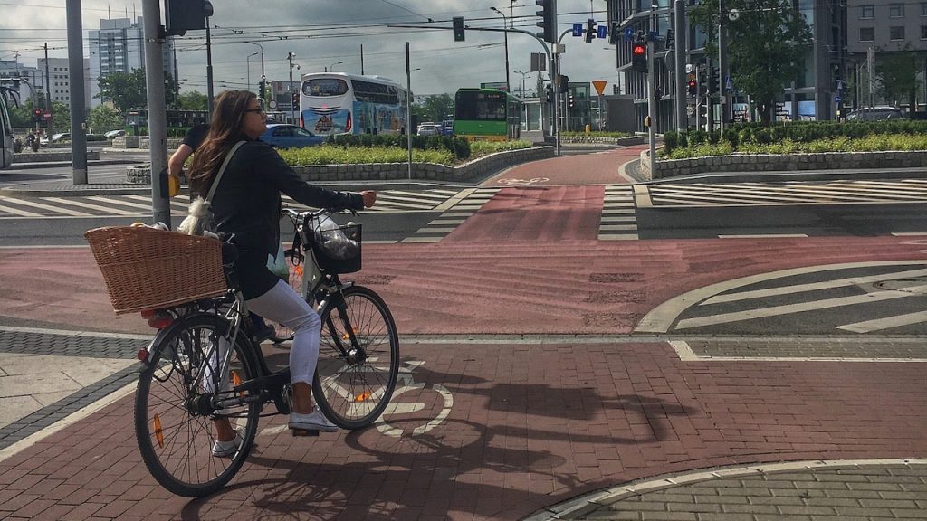Fahrradfahrerin steht in der Stadt an Ampel